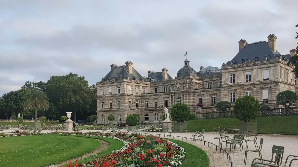 Green chairs and flower beds facing the Luxembourg Palace in Paris